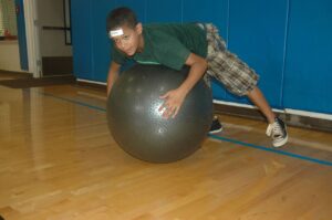 HELEMANO MILITARY RESERVATION, Hawaii - Jordan Cleveland, 12, takes to the air while on an exercise ball during an Excel, Develop, Grow and